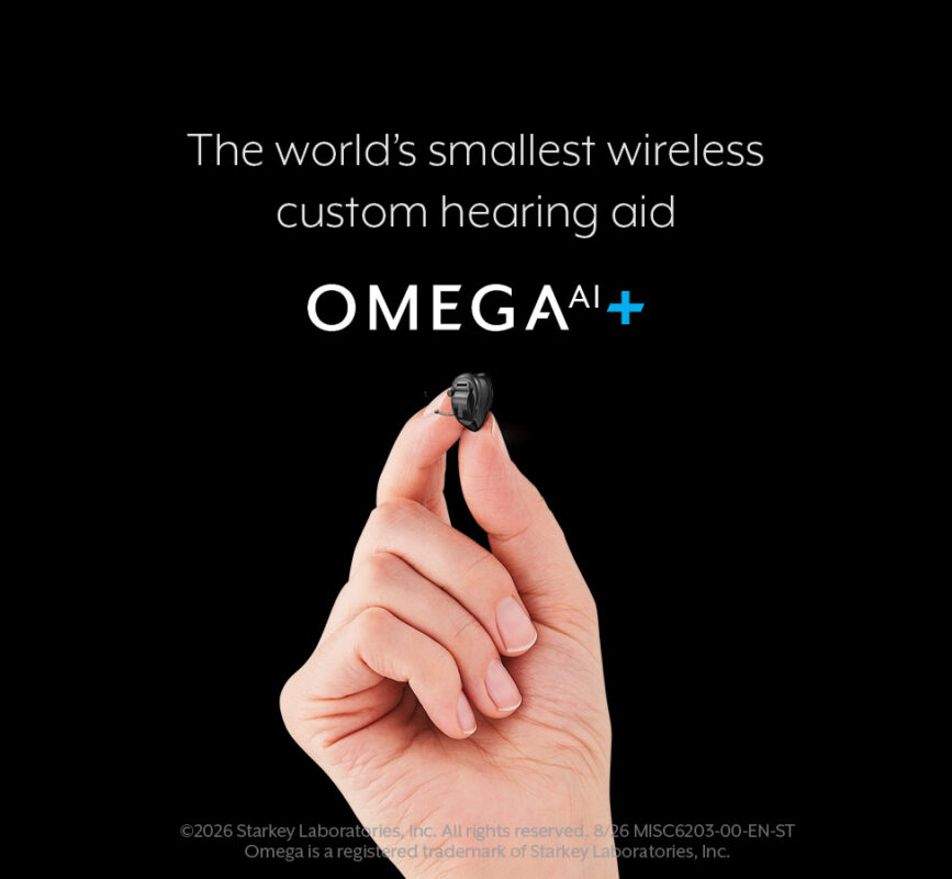 Small Starkey Omega AI+ custom hearing aid held between two fingertips
